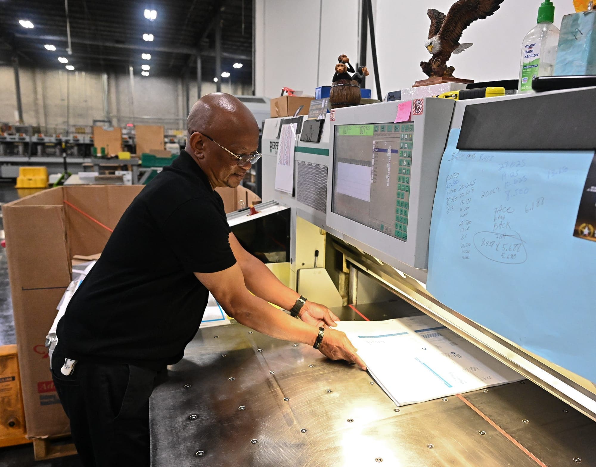 Bindery operator at the Perfecta cutter at Dove Direct